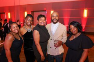653310385_1358080516353273_7083322727913252839_n-300x200 | Akron Urban League Group of Five Adults Posing Together at a Party, Smiling, Under Red Ambient Lighting. (informative)