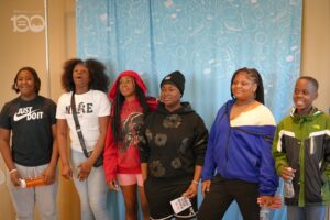 693331672_18226207393314357_3869125880792332149_n-300x200 | Akron Urban League Group of Six Diverse Young People Standing Side by Side, Posing for a Photo in Front of a Blue Curtain Backdrop Indoors.