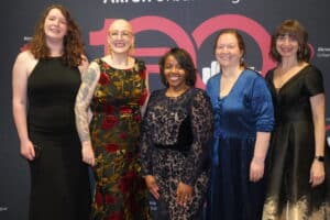 Dsc05436-300x200 | Akron Urban League Five Women in Formal Dresses Posing Together at a Charity Event, in Front of a Pink Heart Backdrop.