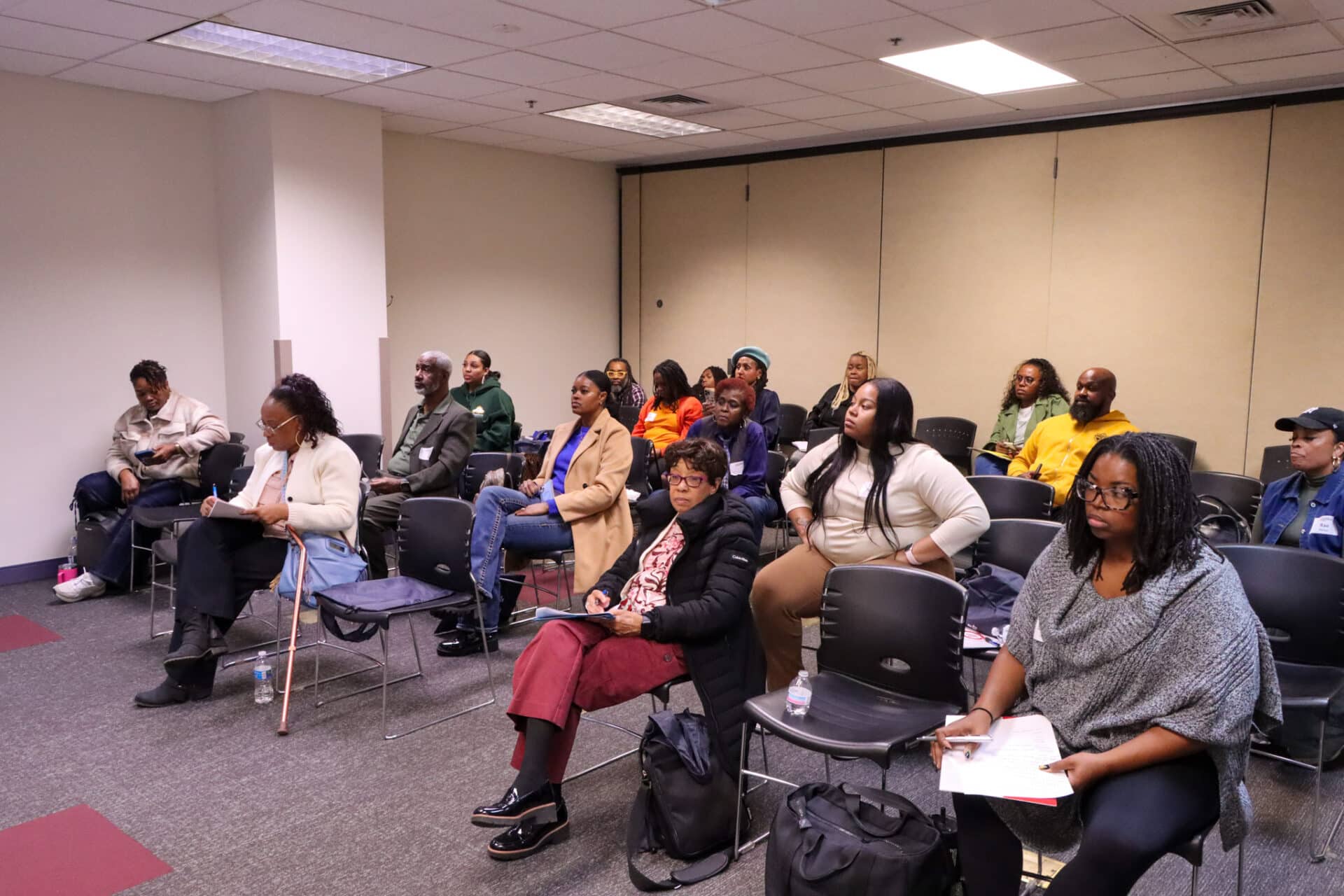 A diverse group of professional students listening attentively during a Minority Business Assistance Center (MBAC) class.
