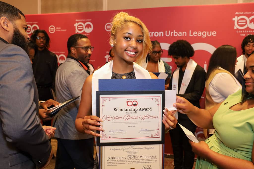 Img_1014 | Akron Urban League Young Woman Smiles As She Holds a Framed Scholarship Award Certificate at an Akron Urban League Event.