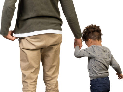 a man and a child holding hands while walking