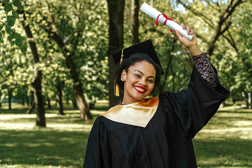 Black high school graduate holding her diploma