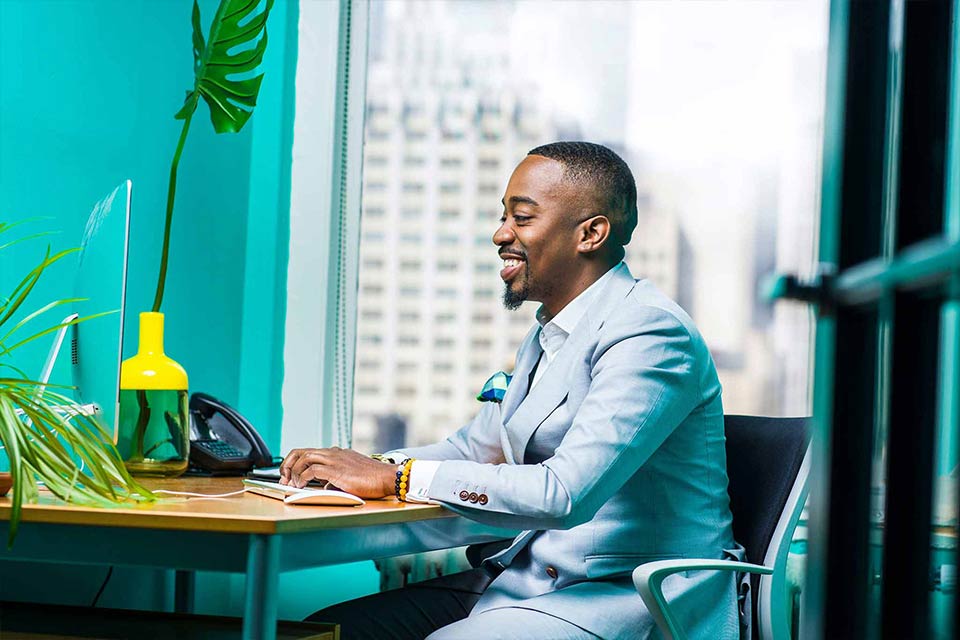 Professional Black man at a desktop computer