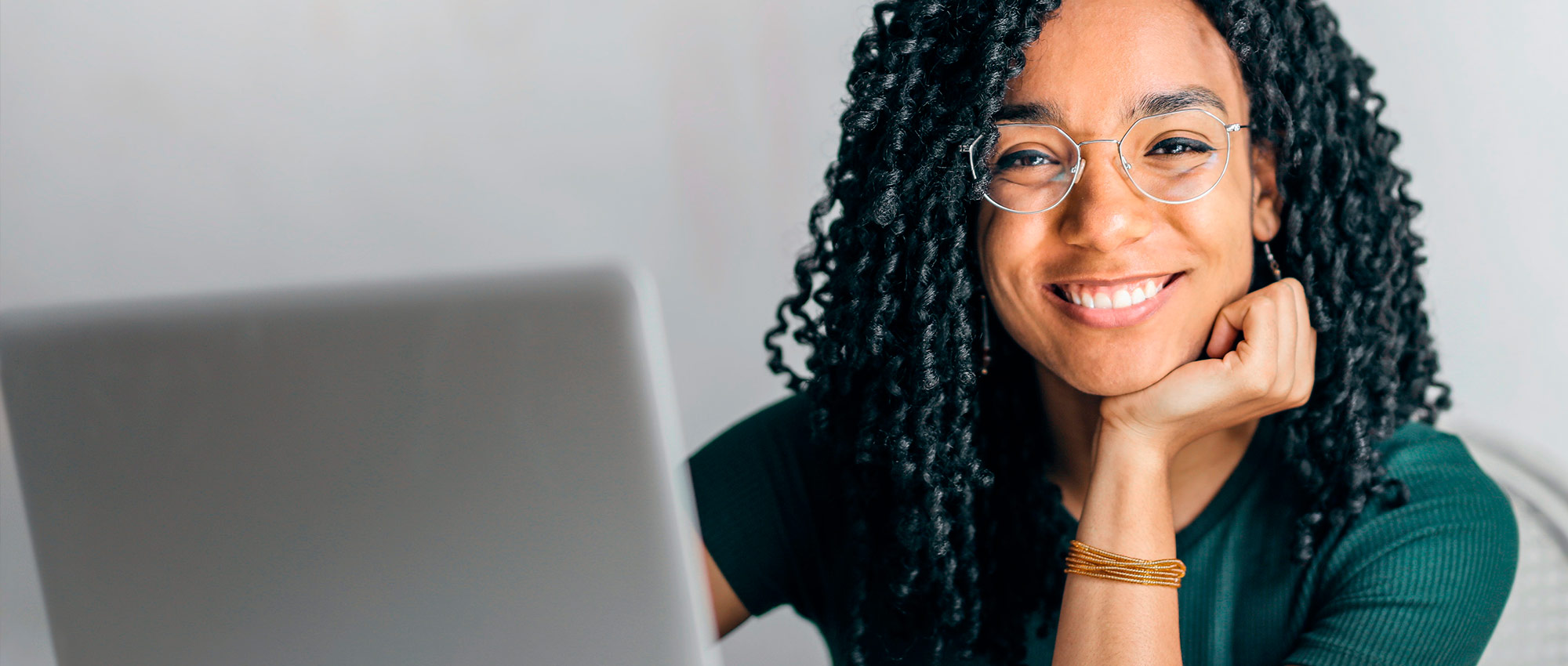 Young Black woman smiling while on her laptop