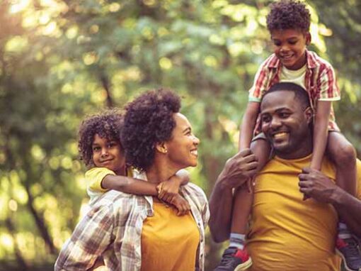 family-walking-in-park-kids-on-shoulders