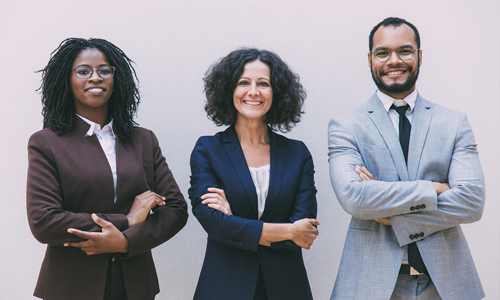 Happy confident business team posing with arms folded