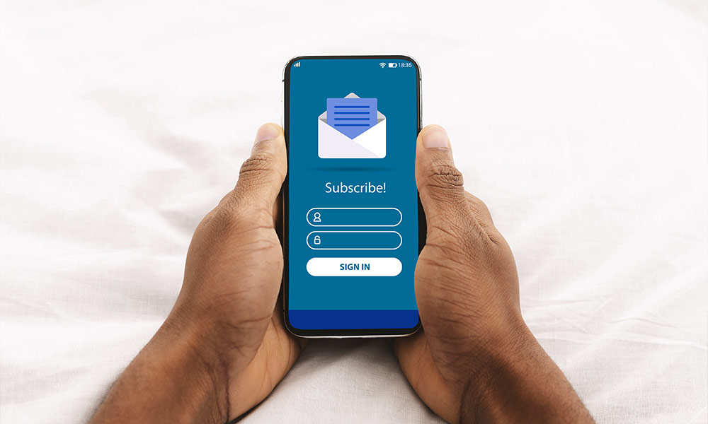 Digital Marketing. Black Man Holding Smartphone With Newsletter Subscription Form On Screen
