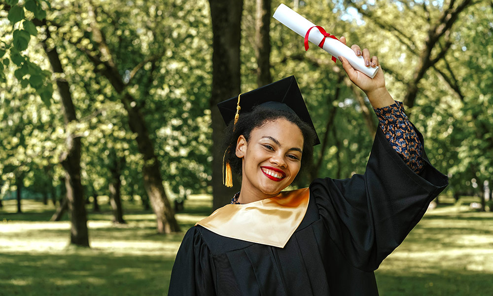 Black high school graduate holding her diploma