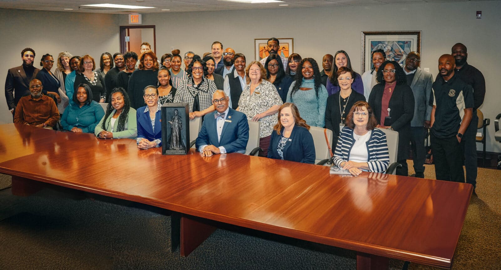 truth-photo | Akron Urban League Large Group of People, Diverse in Age and Race, Posed Around a Long, Polished Wooden Conference Table.